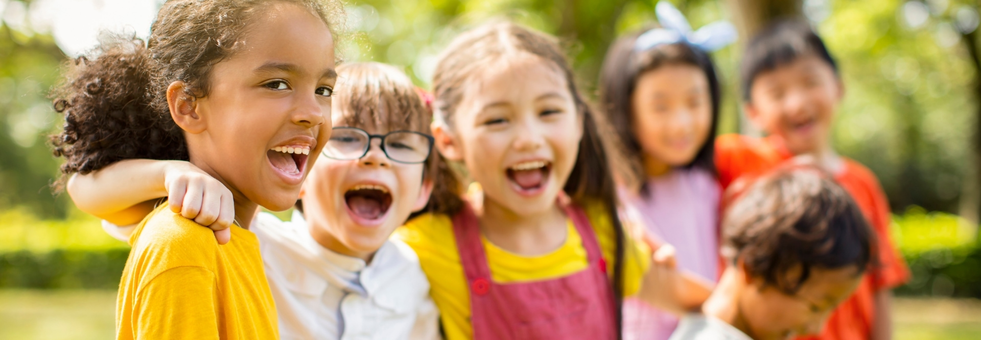 Multi-ethnic group of school children laughing and embracing